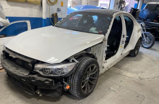 Vehicle undergoing auto body repair inside Frame Auto Collision shop in Nassau County