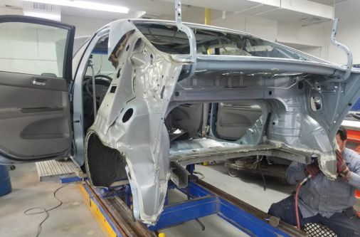 Car inside Frame Auto Collision shop during collision repair in New Hyde Park NY