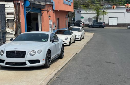 Line of cars parked in front of Frame Auto Collision auto body shop in New Hyde Park NY